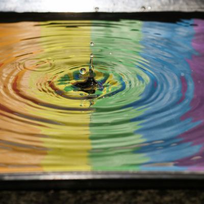 time lapse photography of water ripple prominently showing a rainbow