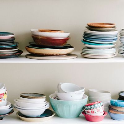 assorted-color ceramic bowls and saucers lot on white wooden shelves