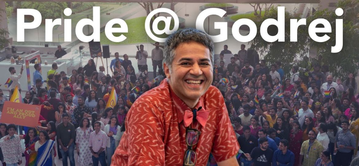 A photo of people celebrating pride in the background and a larger photo of Parmesh Shahani imposed over it in the centre. At the top, there is white text which says "Pride @ Godrej"