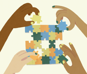 Four hands coming together from the four corners of the image to solve a multi-coloured jigsaw puzzle.