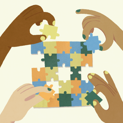 Four hands coming together from the four corners of the image to solve a multi-coloured jigsaw puzzle.