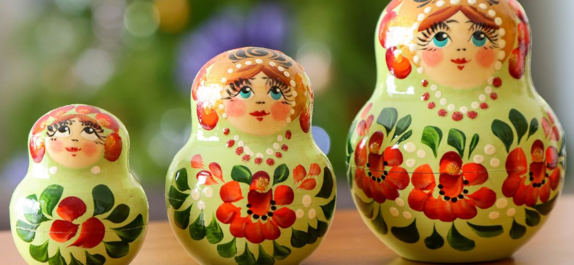 A group of three nesting dolls or matryoshka dolls sitting on top of a wooden table