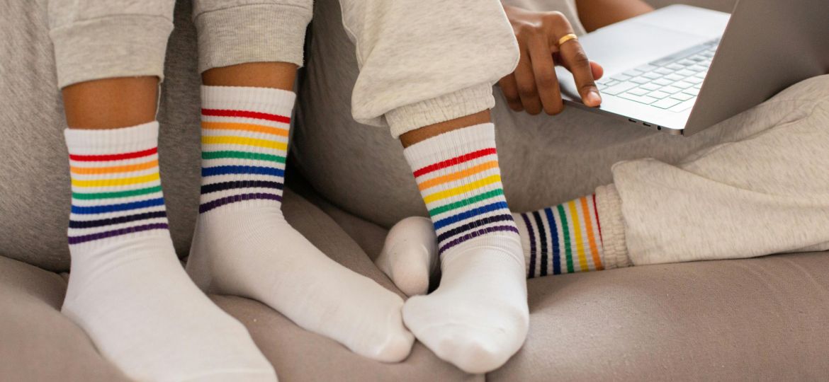 Close-up Photo of People wearing Pride Colored Socks.