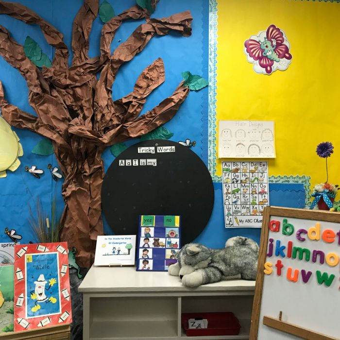 Assorted animal plush toys on white wooden shelf in a classroom setting which seems to be catered to young kids in a primary or elementary school.